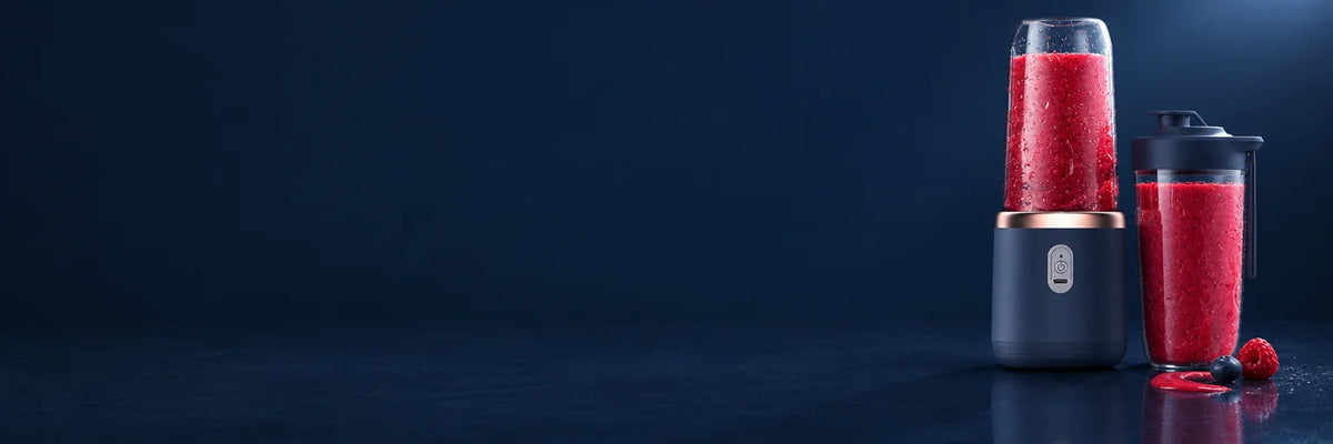 A very wide photograph of the exact dark-blue blender and a closed clear travel cup filled with a fr